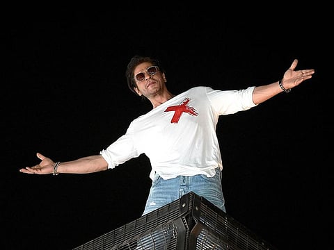 Bollywood actor Shah Rukh Khan strikes his iconic pose as he greets fans during his 58th birthday celebrations at his Mannat residence in Mumbai on November 2, 2023.