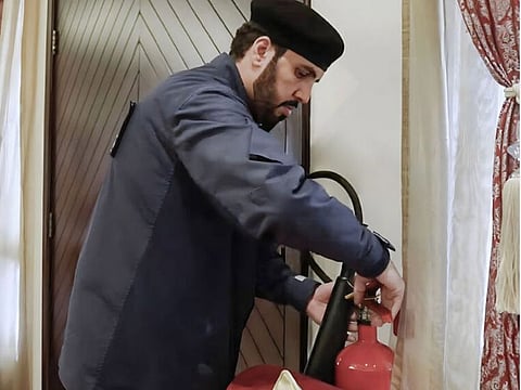 A Civil Defence official checks a fire extinguisher at a venue as part of the awareness campaign