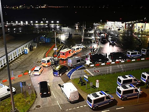 Police vehicles and ambulances arrive at the scene of a security breach at the Hamburg Airport.