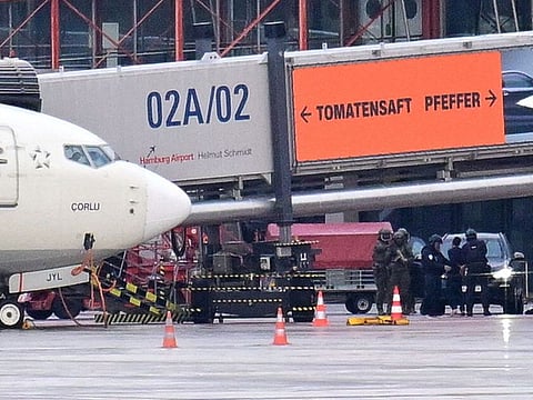 Police officers detain a man, after a man drove through a barrier onto the grounds of the city's airport with a child in his car in Hamburg, Germany, November 5, 2023.