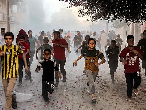 Palestinian children run as they flee from Israeli bombardment in Rafah in the southern Gaza Strip.