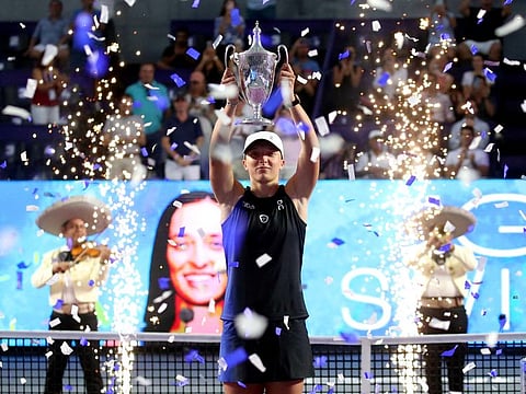 Poland's Iga Swiatek celebrates with the trophy after winning her final match against Jessica Pegula of the US in the WTA Finals at Cancun, Mexico on Monday.