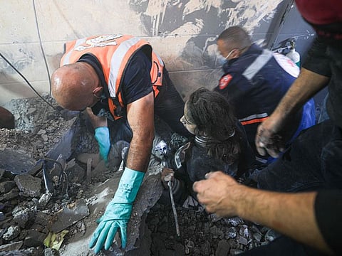 Palestinian rescuers help a victim of Israeli bombardment in Khan Younis in the southern Gaza Strip on November 7, 2023.