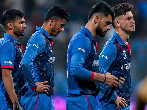 Afghanistan players wear a dejected look after losing their World Cup match against Australia.