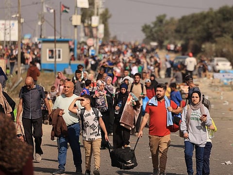 Palestinians families fleeing Gaza City and other parts of northern Gaza towards the southern areas, walk along a highway on November 9, 2023, amid the ongoing battles between Israel and the Palestinian Islamist group Hamas.
