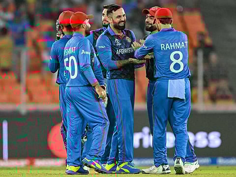 Afghanistan's Mohammad Nabi (centre) celebrates with teammates after dismissing South Africa's David Miller during their final league match in World Cup 2023.