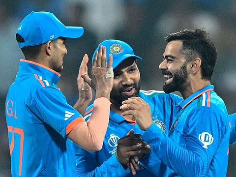 India’s Virat Kohli (right) celebrates with Shubman Gill (left) and captain Rohit Sharma after taking the wicket of Netherlands’ captain Scott Edwards during the 2023 ICC Men's Cricket World Cup match at the M. Chinnaswamy Stadium in Bengaluru on November 12, 2023. India won to extend their win streak to nine matches. They will meet New Zealand in the semifinals on November 15, 2023.