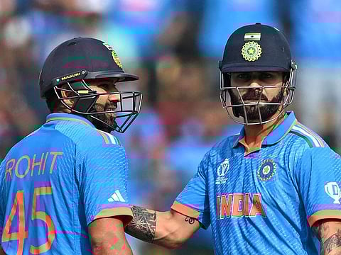 India’s Virat Kohli (right) pats captain Rohit Sharma on scoring a half-century during the 2023 ICC Men's Cricket World Cup match against the Netherlands at the M. Chinnaswamy Stadium in Bengaluru, India, on November 12, 2023. India are two wins away from claiming their third World Cup.
