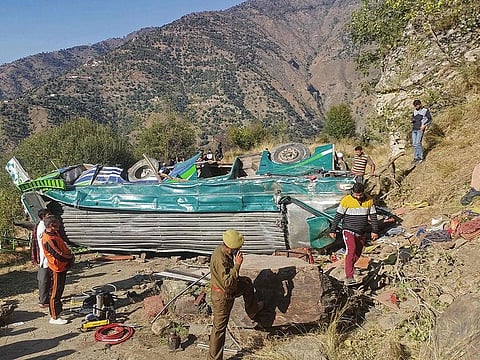 A police officer attends a phone call near the wrecked bus, subject to an accident on a remote mountain road in the Doda area, about 200 kilometres southeast of the Srinagar.