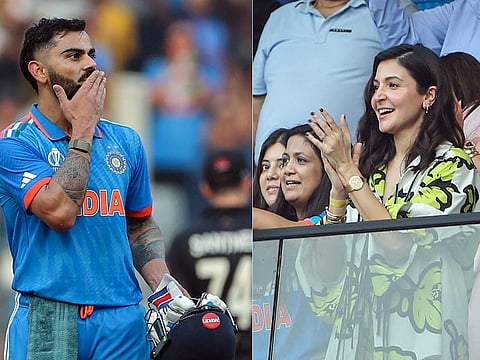 (Combo Picture) India's Virat Kohli blows a flying kiss to his wife Anushka Sharma as she applauds his century during the semi-final match against New Zealand in the ICC Men's Cricket World Cup 2023, at Wankhede Stadium in Mumbai on Wednesday.