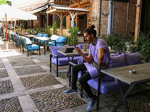 A worker waits for costumers at a restaurant in Lebanon's coastal historical city of Byblos.