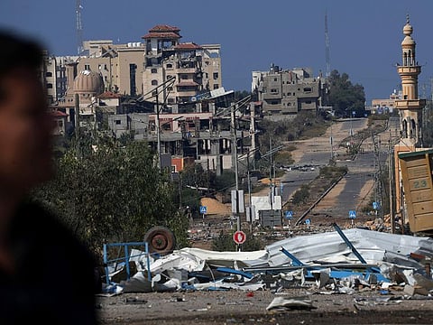 Palestinian man walks on the rubble of destroyed building after an Israeli airstrike, while others fleeing to the southern Gaza Strip along Salah al-Din Street, outskirts of Gaza City.
