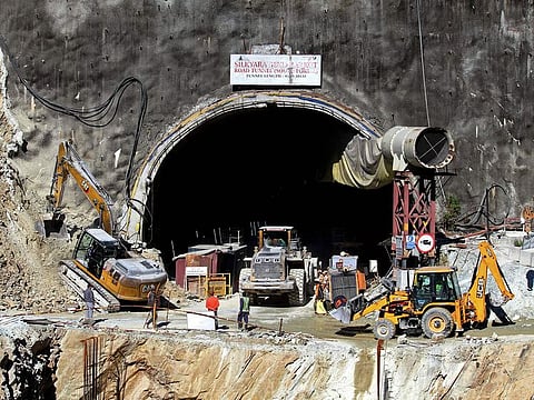 Rescue workers stand at an entrance of the under construction road tunnel, days after it collapsed in the Uttarkashi district of India's Uttarakhand state.