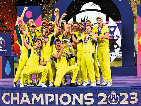 Australia's players celebrate with the trophy after winning the 2023 ICC Men's Cricket World Cup one-day international (ODI) final match against India at the Narendra Modi Stadium in Ahmedabad.