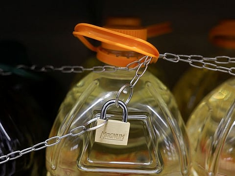 Olive and sunflower oil bottles are displayed for sale, protected by a padlock and a chain to prevent theft in a Tu Super Suma supermarket in Malaga, Spain, October 23, 2023.