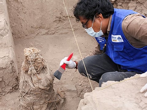 An archaeologist works on one of five mummies, that according to archaeologists belong to the pre-Inca Ychsma culture that inhabited the central coast of Peru from approximately 900 to 1450 AD., at the Huaca La Florida archaeological site, in Lima, Peru, November 21, 2023.