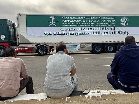 Drivers sit by trucks carrying Saudi aid to the Gaza Strip as the convoy waits in El Arish, in Egypt some 40km from the Rafah crossing with Gaza.