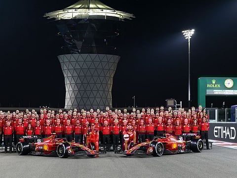 Carlos Sainz and Charles Leclerc of Ferrari with team members during a group photo during the Formula 1 Etihad Airways Abu Dhabi Grand Prix at Yas Marina Circuit yesterday.