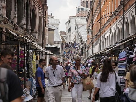 Tourists walk in a crowded street in Venice, Italy, Wednesday, Sept. 13, 2023.