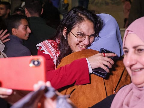 Raghad Fan (C) a Palestinian prisoner held in an Israeli prison is greeted by her family on her release under a truce deal between Israel and Hamas in exchange for hostages held in Gaza, in Baytunia on November 24, 2023.