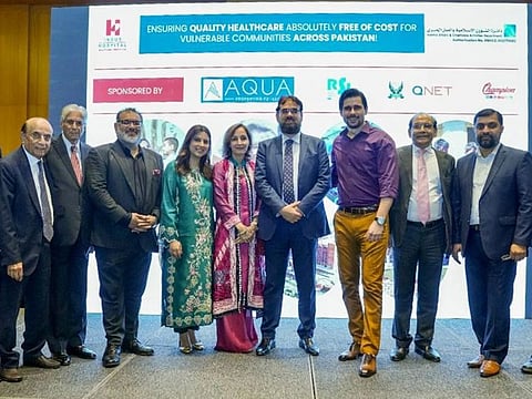 Dr Abdul Bari, founder of Indus Hospital and Health Network (4th from L) stands for a photographer with donors at an patient support event held in Dubai.