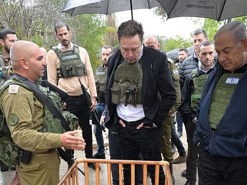Elon Musk, centre, and Benjamin Netanyahu, right, in Kfar Aza on November 27.