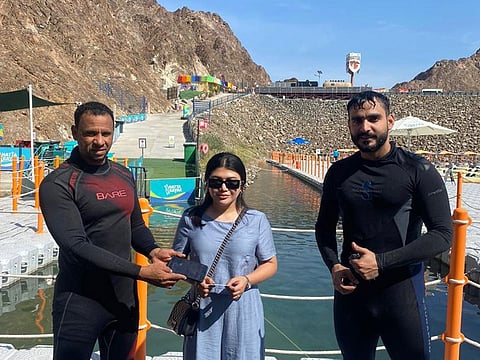 Filipina tourist Yao Long (centre) receiving her mobile phone that was retrieved by police divers from the lake of Hatta dam in Dubai emirate recently