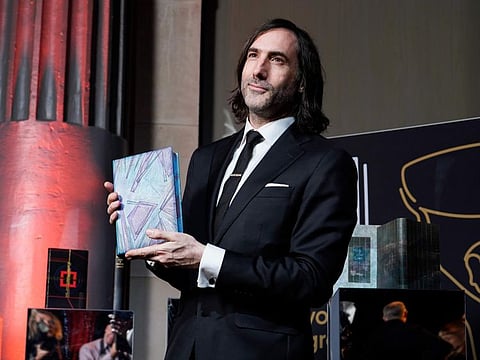 Paul Lynch poses with his book as he arrives at the Booker Prize award dinner, in London, on November 26, 2023.
