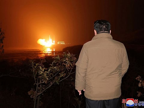 North Korean leader Kim Jong Un looks on as a rocket carrying a spy satellite Malligyong-1 is launched.