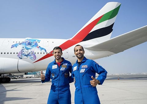 Emirati astronauts Dr Sultan Al Neyadi and Hazzaa Al Mansoori standing for photograph in front of Emirates's special flight that flew across the UAE on Tuesday to celebrate the country’s space achievements