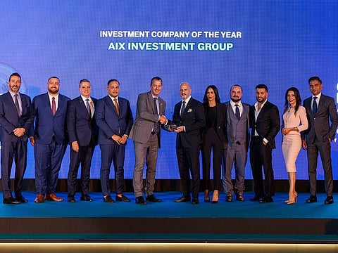 AIX Investment Group's leaders, including the President of the Board and COO, hold the "Investment Company of the Year" trophy at the Gulf Business Awards 2023.