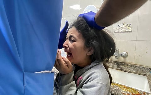 A Palestinian girl wounded in an Israeli strike is assisted, after a temporary truce between Hamas and Israel expired, at Nasser hospital in Khan Younis in the southern Gaza Strip, December 1, 2023