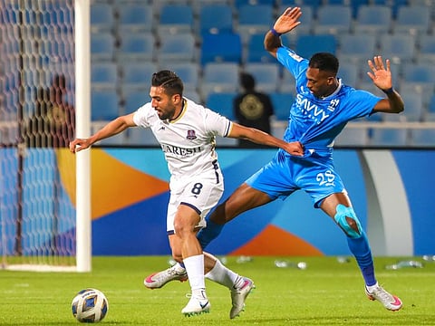 Nassaji's Iranian forward Mehrdad Abdi (left) is marked by Hilal's Saudi midfielder Mohamed Kanno during the AFC Champions League Group D match at Prince Faisal Bin Fahd Stadium in Riyadh on Monday.