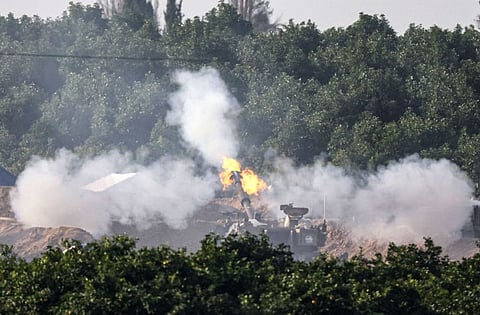 A picture taken from southern Israel near the border with the Gaza Strip on December 4, 2023, shows an Israeli tank firing at the Palestinian territory following amid continuing battles between Israel and the militant group Hamas.