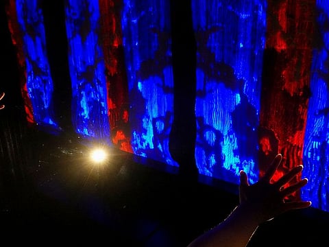 A researcher demonstrates an installation composed of intelligent textiles that change colour in response to hand movements and gestures in Hong Kong.