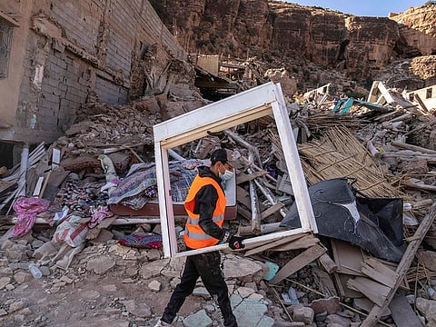 A volunteer helps salvage furniture from homes which were damaged by the earthquake, in the town of Imi N'tala, outside Marrakech, Morocco,