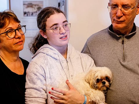 Mia Leimberg, 17, released from captivity after being taken hostage by Hamas in the Gaza Strip with her mother Gabriela and her dog Bella, as she stands with her mother and father, Moshe, at their home in Jerusalem, on December 5, 2023.