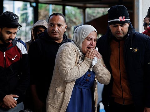 A Palestinian woman mourns near the bodies of Palestinians killed in Israeli strikes on houses, at Abu Yousef al-Najjar hospital in Rafah