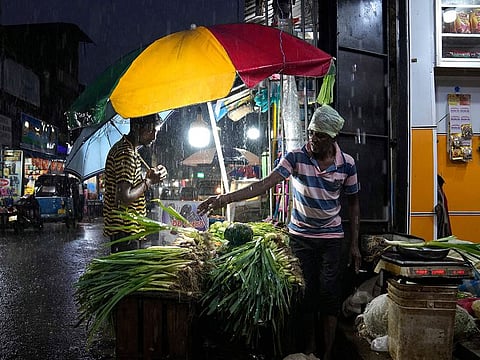 A roadside vendor sells vegetables at a market place in Colombo, Sri Lanka, Friday, Dec. 8, 2023.