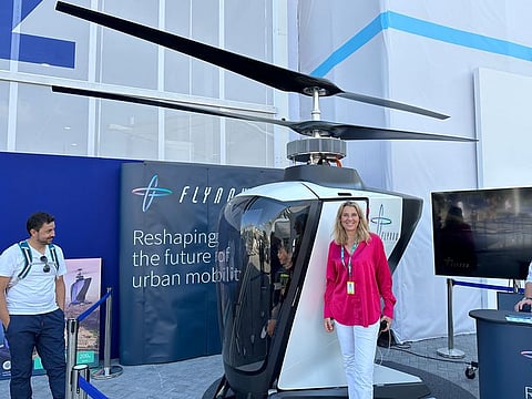 Yvonne Winter, COO and co-founder of Flynow, beside the prototype of a mini helicopter made by the Austria-based company, displayed at the Science and Technology Hub of COP28 UAE in Dubai on December 9, 2023.