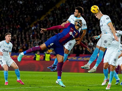 Barcelona's defender Ronald Araujo, Girona's defender Eric Garcia (top) and forward Artem Dovbyk (right) battle for the ball during the Spanish league match at the Estadi Olimpic Lluis Companys in Barcelona on Sunday.