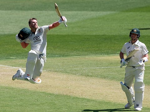 Australias David Warner celebrates his century as teammate Steve Smith applauds during the first day of the first Test against Pakistan at Optus Stadium in Perth on Thursday.