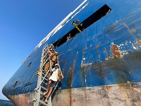 People walk down a ladder after they toured the Galaxy Leader commercial ship, seized by Yemen's Al Houthis last month, off the coast of Al Salif.