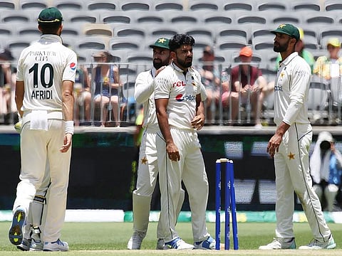 Pakistan's bowler Aamer Jamal (C) is congratulated by teammates after taking the wicket of Australia's Mitchell Starc on day two of the first Test in Perth on December 15, 2023.