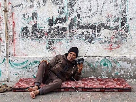 A Palestinian man listens to radio in a refugee camp in Rafah in the southern Gaza Strip on December 17, 2023.