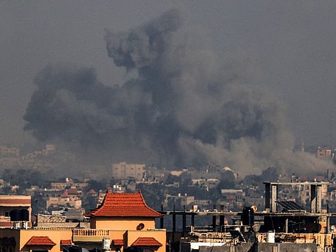 Smoke billowing above buildings during Israeli bombardment on Khan Yunis in the southern Gaza Strip.