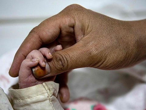 An Afghan woman holds the hand of her newborn child at the Doctors Without Borders (MSF)-run maternity hospital in Khost.