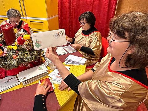 Kornelia Matzke, right, and her colleagues prepare thousands of replies, each with a special stamp in Himmelpfort, Germany, on December 21.