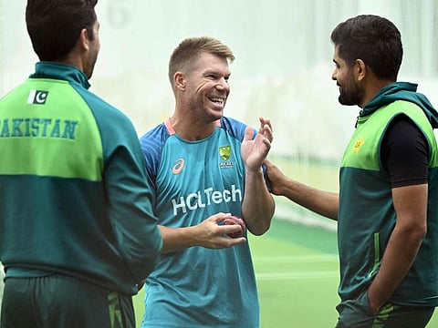 Australia's David Warner shares a joke with Pakistan's batsman Babar Azam (right) and bowling coach Umar Gul during a training session at the Melbourne Cricket Ground on Monday.