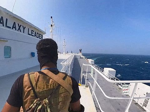 An Al Houthi militant stands on the Galaxy Leader cargo ship in the Red Sea in this photo released November 20, 2023.  The Iran-backed Al Houthi militia have attacked commercial vessels sailing the sea since October, a campaign the group says is in solidarity with Palestinians in Gaza besieged by Israel.